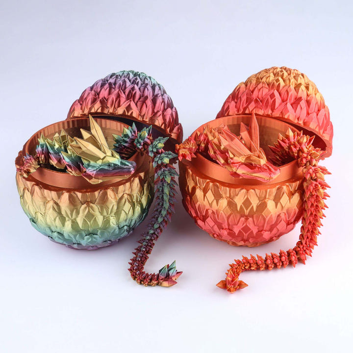Three iridescent dragon eggs, two closed and one open, with matching dragon figures emerging from inside, displayed on a clean white background.