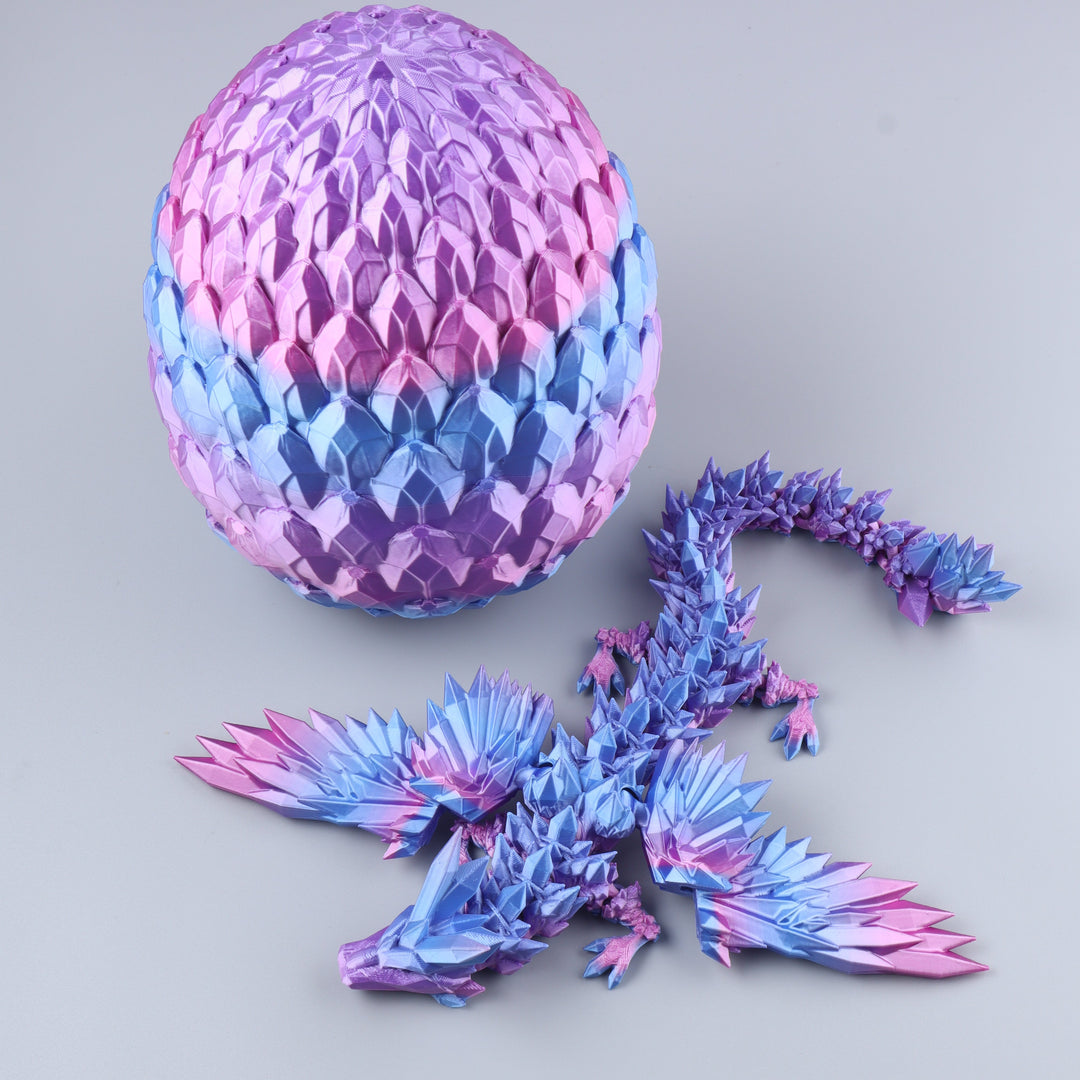 A 3D-printed origami dragon toy next to its matching spherical egg, both featuring a vibrant blue, purple, and pink gradient design on a neutral gray background.