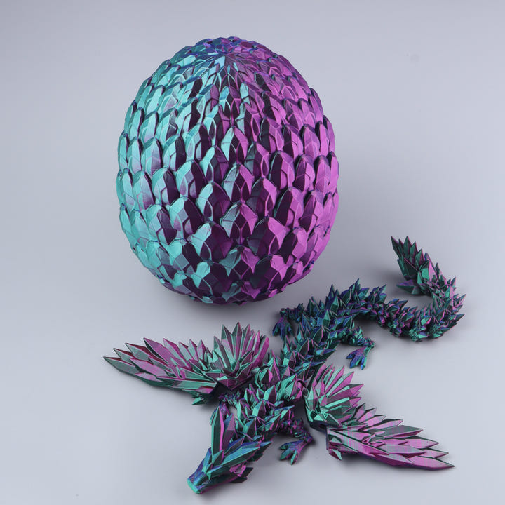A metallic dragon puzzle set featuring a large iridescent egg-shaped shell and several matching dragon pieces in the foreground, photographed on a clean light gray studio background.