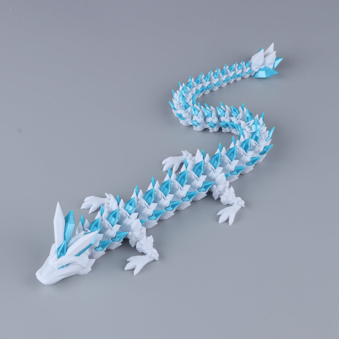 A white and light blue dragon figurine, styled like an origami model, displayed diagonally on a smooth gray background.