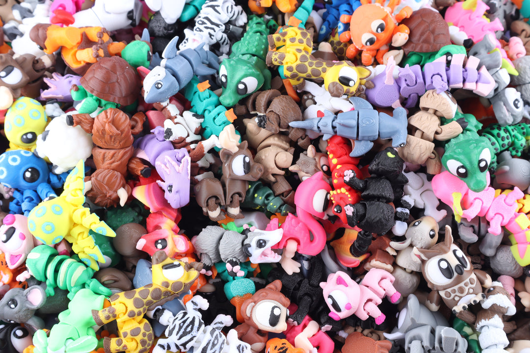 A dense pile of small colorful animal-shaped toy figures, including crocodiles, giraffes, monkeys, birds, and other cartoon creatures, filling the frame.