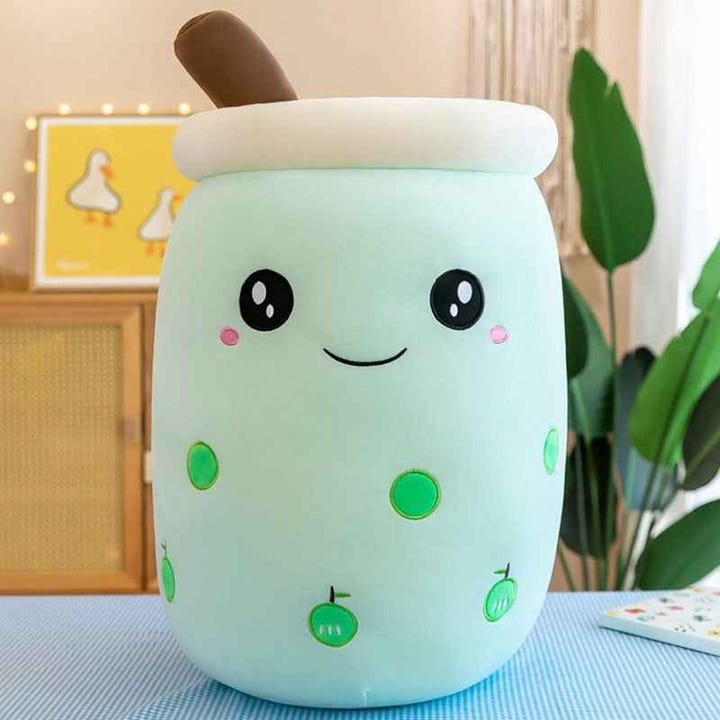 Cute plush toy resembling a bubble tea with a smiling face on a table.