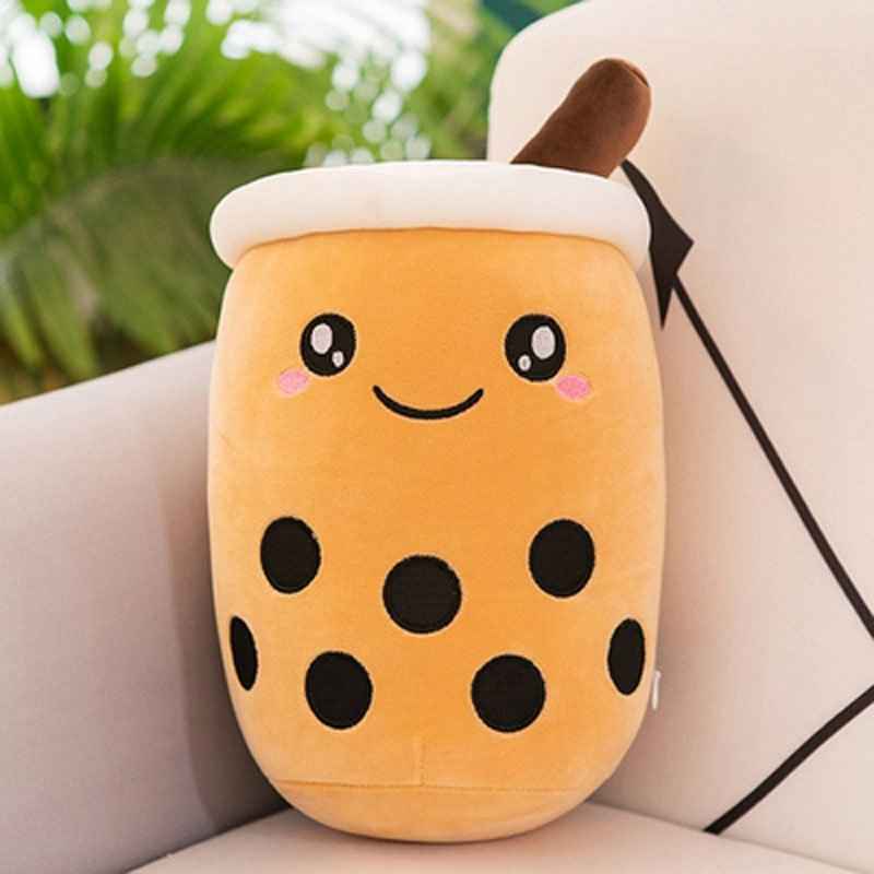 Plush toy shaped like a bubble tea cup with a smiling face on a couch.